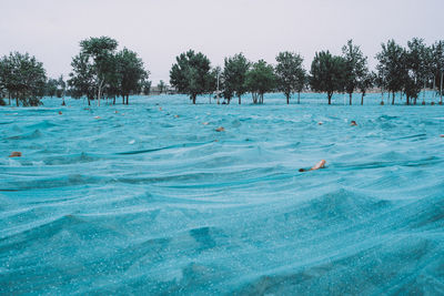 People swimming in pool by sea against clear sky