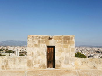 Closed door on historical building against cityscape and blue sky