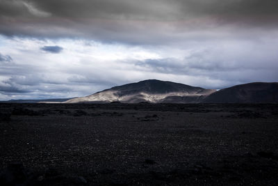 Scenic view of field and mountains against sky