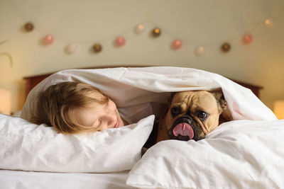 Midsection of woman with dog on bed