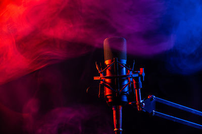 Professional microphone in pink smoke on a black background.