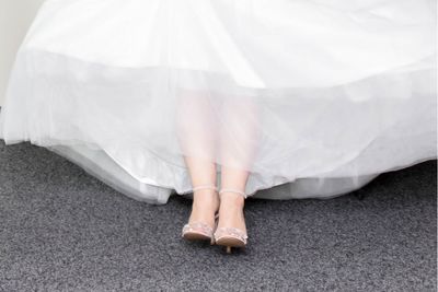 Low section of woman wearing dress on carpet
