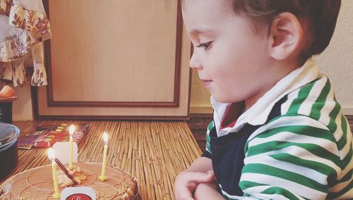 Portrait of boy looking on the candles on the birthday cake 