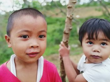 Close-up of siblings outdoors