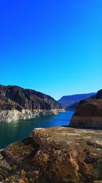 Scenic view of lake against clear blue sky