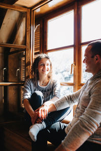 Happy friends sitting at window