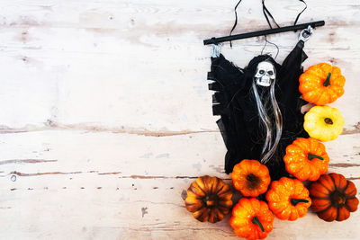 Directly above view of pumpkins and witch against wooden table