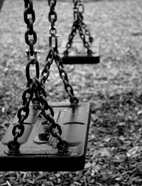Close-up of swing hanging on chain