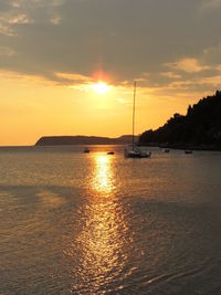 Boats in sea at sunset
