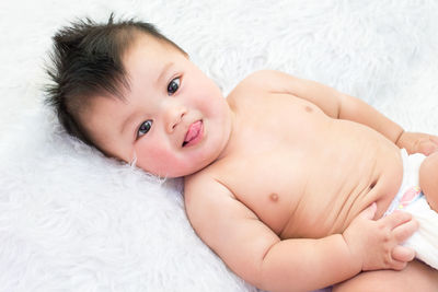 Portrait of cute baby lying on bed