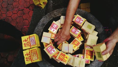 Cropped image of person picking up fortune notes bundles in container