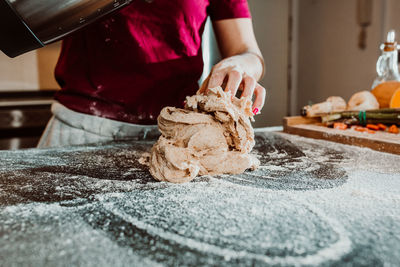 Midsection of woman holding ice cream in kitchen