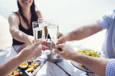 Midsection of woman holding wineglass