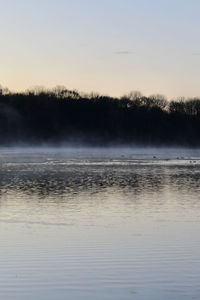 Scenic view of lake against sky during foggy weather