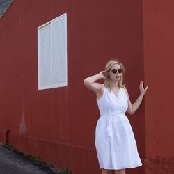 Beautiful woman standing by building wall