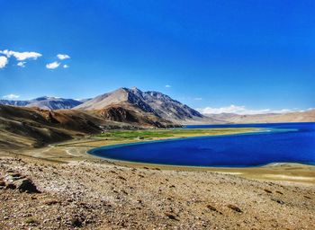 Scenic view of landscape and mountains against blue sky