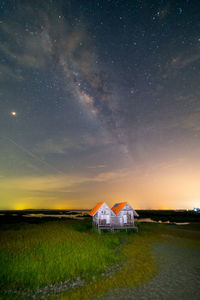 House on field against sky at night