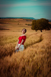 Portrait of woman with umbrella on field