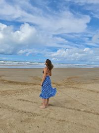 Rear view of woman standing on beach