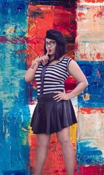 Full length of woman standing against multi colored wall