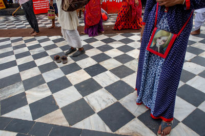 Low section of people walking on tiled floor