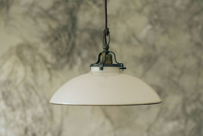 Close-up of electric lamp against wall