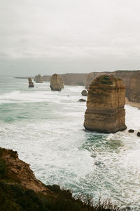 Rocks on sea shore against sky