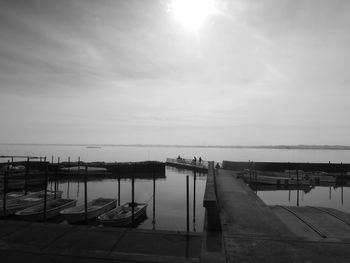 Boats moored at harbor against sky