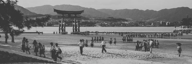 Group of people on beach against mountains