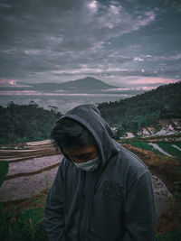 Portrait of man standing against sky during winter