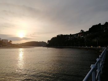 Panoramic view of sea and buildings against sky during sunset