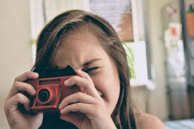Portrait of young woman photographing camera