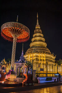 Illuminated temple building against sky at night