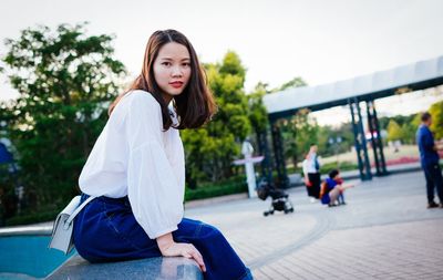 Portrait of woman sitting by fountain