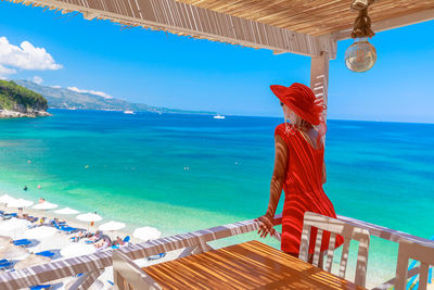 Rear view of woman looking at sea against sky