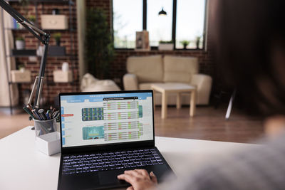 Midsection of woman using laptop at office