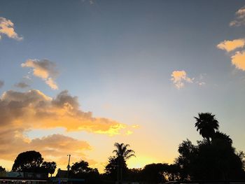 Low angle view of silhouette trees against dramatic sky