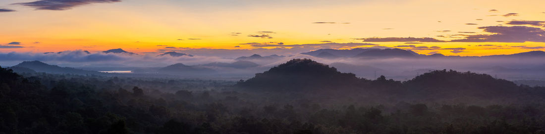 Scenic view of mountains against orange sky