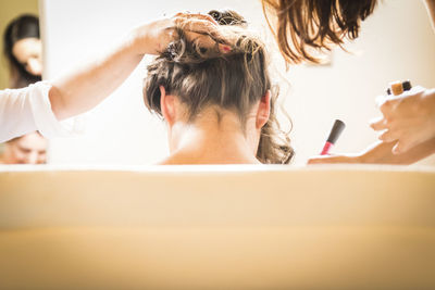 Hairdressers applying make-up of woman body in salon