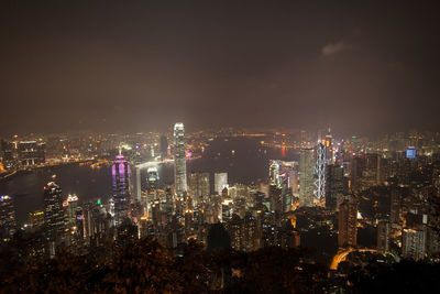 Illuminated cityscape against sky at night