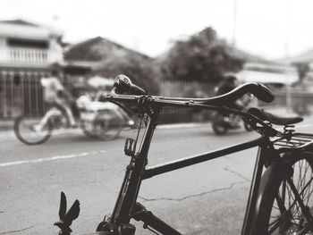 Close-up of bicycle parked on road against city