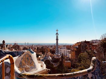 Buildings in city against clear blue sky