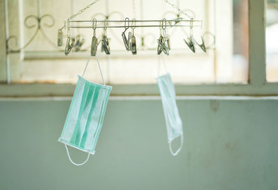 Close-up of clothes hanging on clothesline against wall