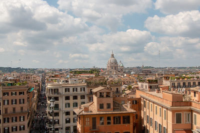 View of buildings in town against cloudy sky