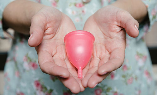 Midsection of woman holding menstrual cup