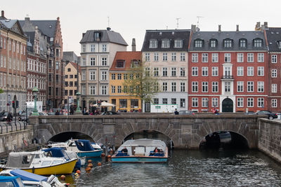 View of boats in river with buildings in background