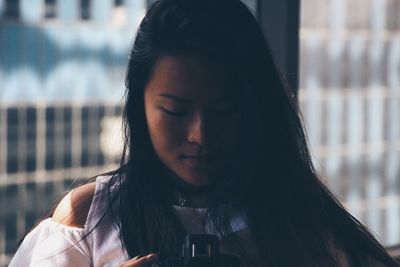 Close-up of young woman operating camera