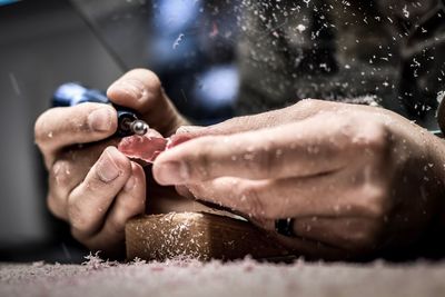 Midsection of man carving wood