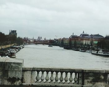 View of river in city against cloudy sky