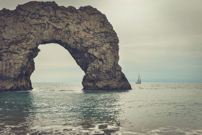 Rock formations on sea shore against sky